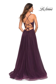 A woman stands facing away in the Corset-Back Long La Femme A-Line Prom Dress, featuring a floor-length deep purple hue, crisscross open back, and flowing tulle skirt.