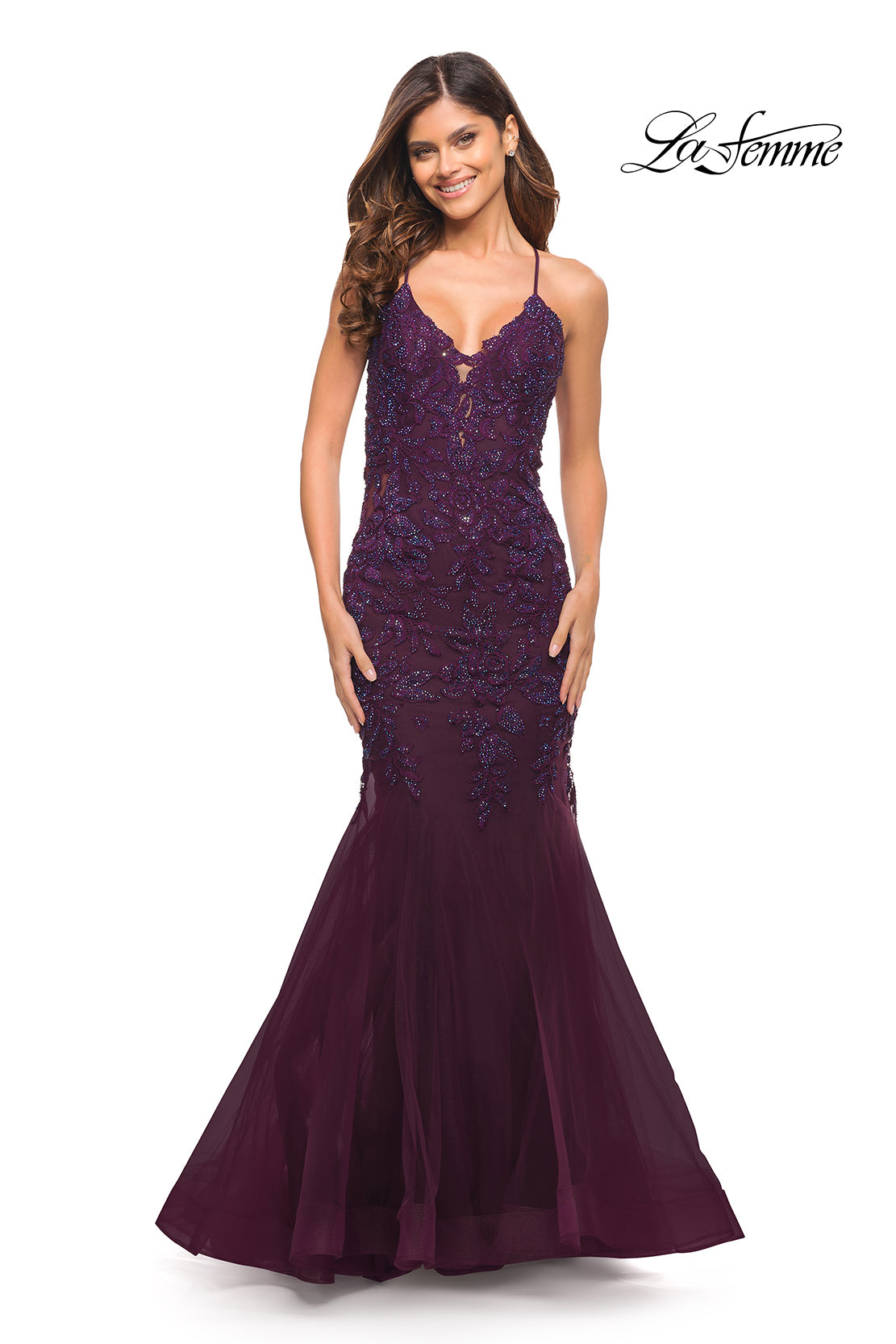 A woman in a sleeveless, dark berry Backless Long Lace Mermaid Prom Dress by La Femme with sequin accents stands smiling, facing forward. The 