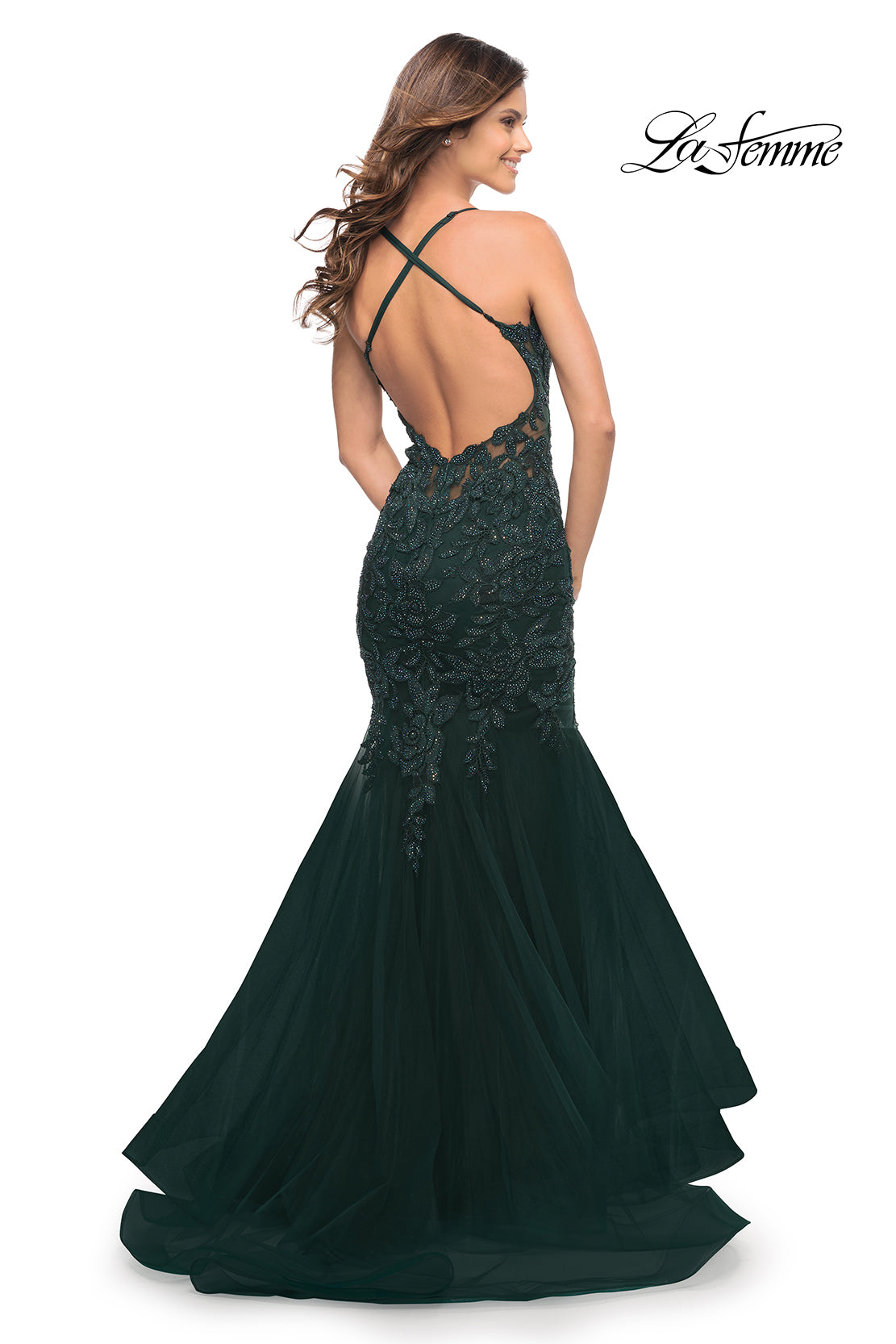 Woman wearing a dark green Backless Long Lace Mermaid Prom Dress by La Femme with a low, open back and crisscross straps. The 