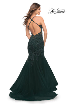 Woman wearing a dark green Backless Long Lace Mermaid Prom Dress by La Femme with a low, open back and crisscross straps. The "La Femme" logo appears in the top right corner.
