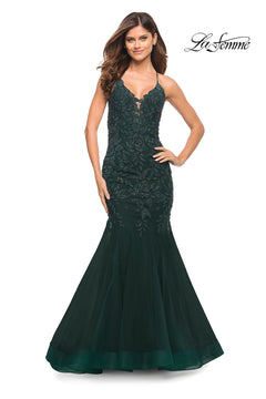 A woman models the Backless Long Lace Mermaid Prom Dress by La Femme—dark green, sleeveless, sequin-detailed lace—standing before a white background with the "La Femme" logo in the top right corner.