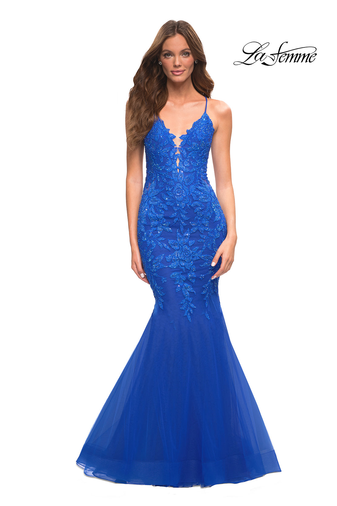 A woman models the Backless Long Lace Mermaid Prom Dress by La Femme in bright blue, featuring thin straps, against a plain white background with the 