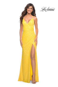 Woman wearing the La Femme Faux-Wrap Long Sequin Formal Gown, a sleeveless, yellow, floor-length evening dress featuring a deep V-neckline, high slit, and sparkling fabric. The "La Femme" logo appears in the upper right corner.