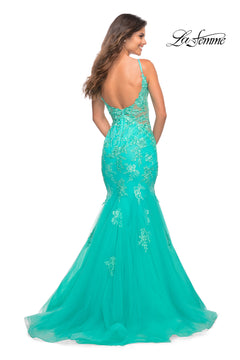 A woman stands facing away in the Aqua Blue Long Lace Prom Dress: La Femme 30675, featuring thin straps, a sheer back panel, and floral embroidery. The La Femme logo appears in the top right corner.