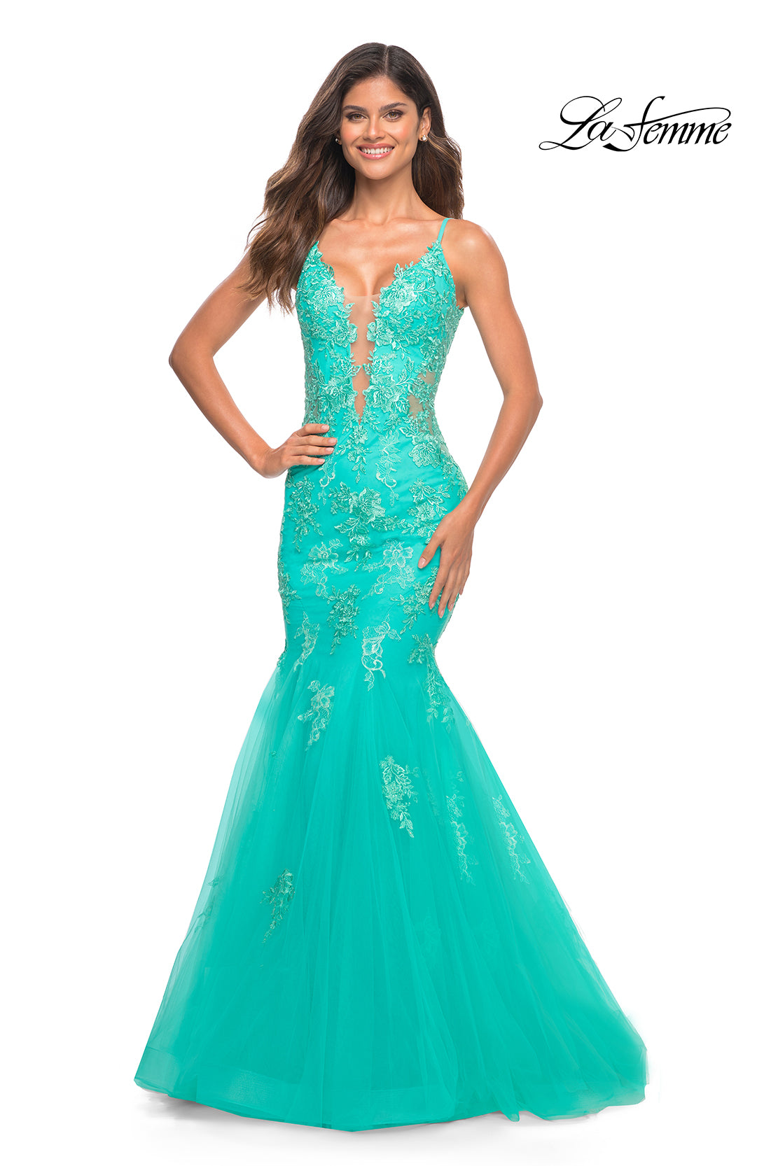 A woman smiles against a plain white background wearing the Aqua Blue Long Lace Prom Dress: La Femme 30675, featuring a mermaid silhouette and plunging neckline.