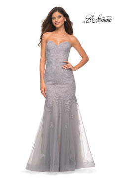 Model in Sheer-Back La Femme Strapless Mermaid Prom Dress—grey lace, floral embroidery, corset back, and flowing tulle skirt. La Femme logo top right.