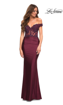 A woman models the burgundy Lace-Bodice La Femme Off-the-Shoulder Prom Dress with a sheer lace bodice and fitted skirt against a white background. The "La Femme" logo appears in the top right corner.
