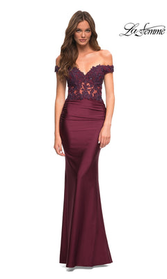 A woman stands against a white background wearing the Lace-Bodice La Femme Off-the-Shoulder Prom Dress in Dark Berry, which features a sheer lace bodice.
