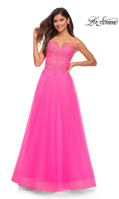A woman poses against a white background in a La Femme Neon Pink Long Ball Gown with Lace, featuring a fitted bodice and flowing skirt.
