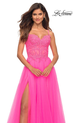 A woman models the La Femme Neon Pink Long Ball Gown with Lace, featuring spaghetti straps, a lace bodice, and a high slit, set against a white background. The "La Femme" logo appears in the top right corner.