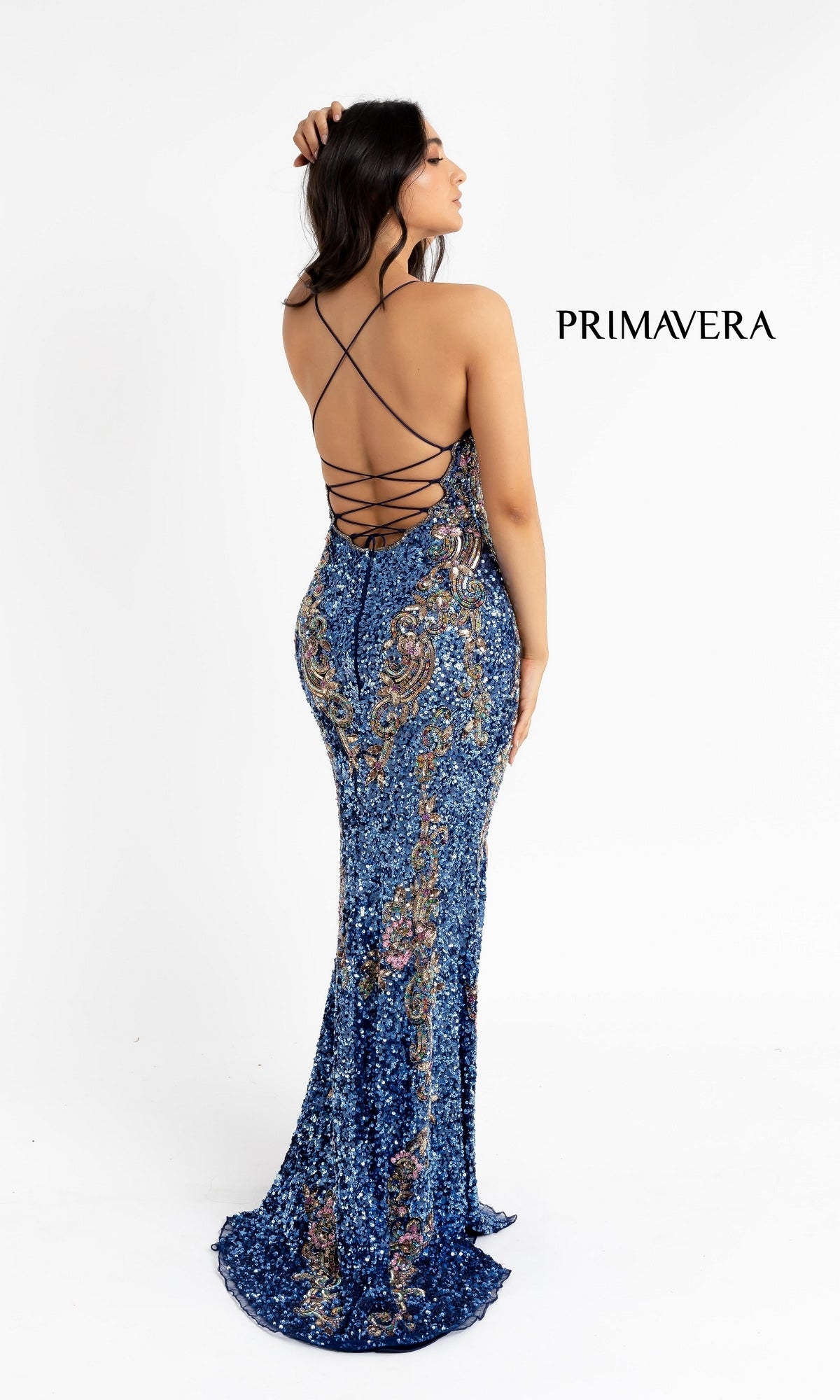 A woman poses with her back to the camera in a V-Neck Sequin Long Prom Gown with lace-up back, showcasing crisscross straps and shimmering blue sequins against a plain white background. 