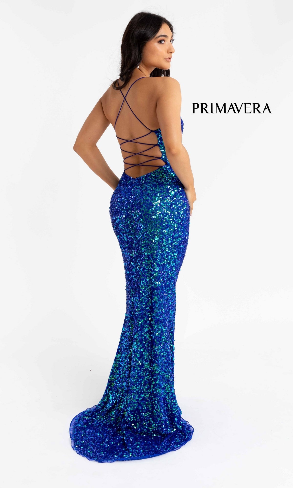 A woman wearing the Open Back Bold Long Sequin Prom Dress 3290D in blue, featuring a floor-length design, open back, and crisscross straps stands against a white background with 