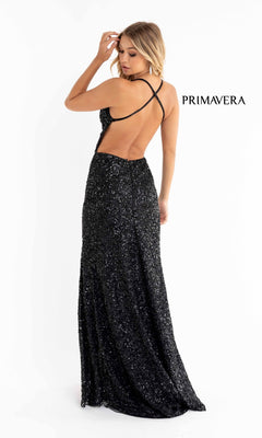 A woman models the Backless Tight Long Sequin Prom Dress 3291D, a floor-length black gown with a crisscross open back, set against a plain white background. The word "PRIMAVERA" is displayed nearby.