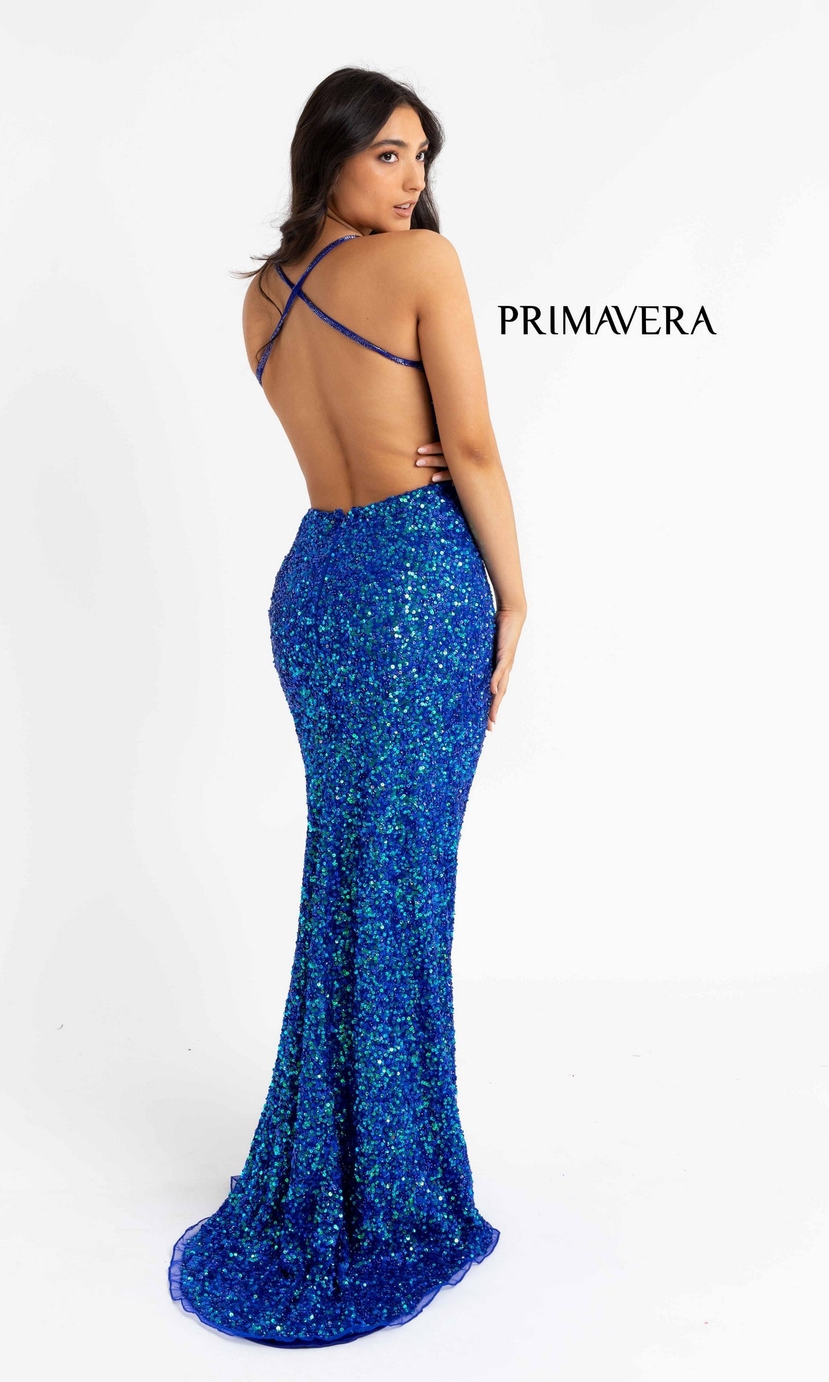 A woman models the Backless Tight Long Sequin Prom Dress 3291D, featuring blue sequins, an open back, and crisscross straps, against a white backdrop. 