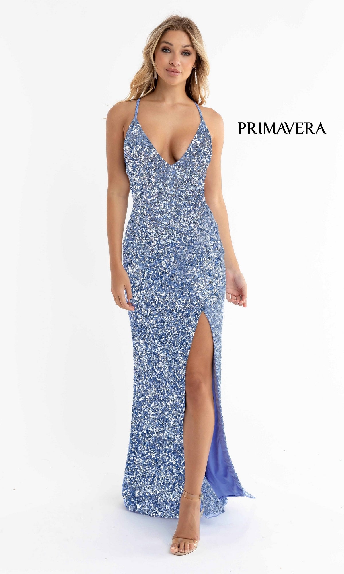 A woman poses in the Deep V-Neck Long Sequin Prom Dress with a thigh-high slit. The dress is sleeveless and blue. The background is plain white with 