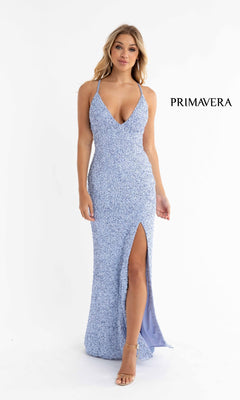 A woman in the Open-Back Bright Long Sequin Prom Dress 3291B, a light blue sleeveless floor-length gown with spaghetti straps and a thigh-high slit, stands against a white background. The word "PRIMAVERA" is beside her.