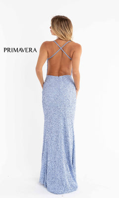 A woman faces away in the Open-Back Bright Long Sequin Prom Dress 3291B—a floor-length, light blue gown with thin crisscross straps and an elegant backless design. The "PRIMAVERA" brand name appears on the left.