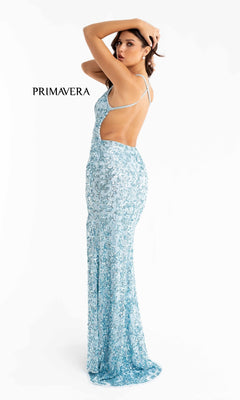 A woman in the Pastel Sequin-Pattern Long Prom Dress 3295 stands with one arm raised; the fitted, floor-length gown shimmers in light blue. "PRIMAVERA" text is displayed on the left.
