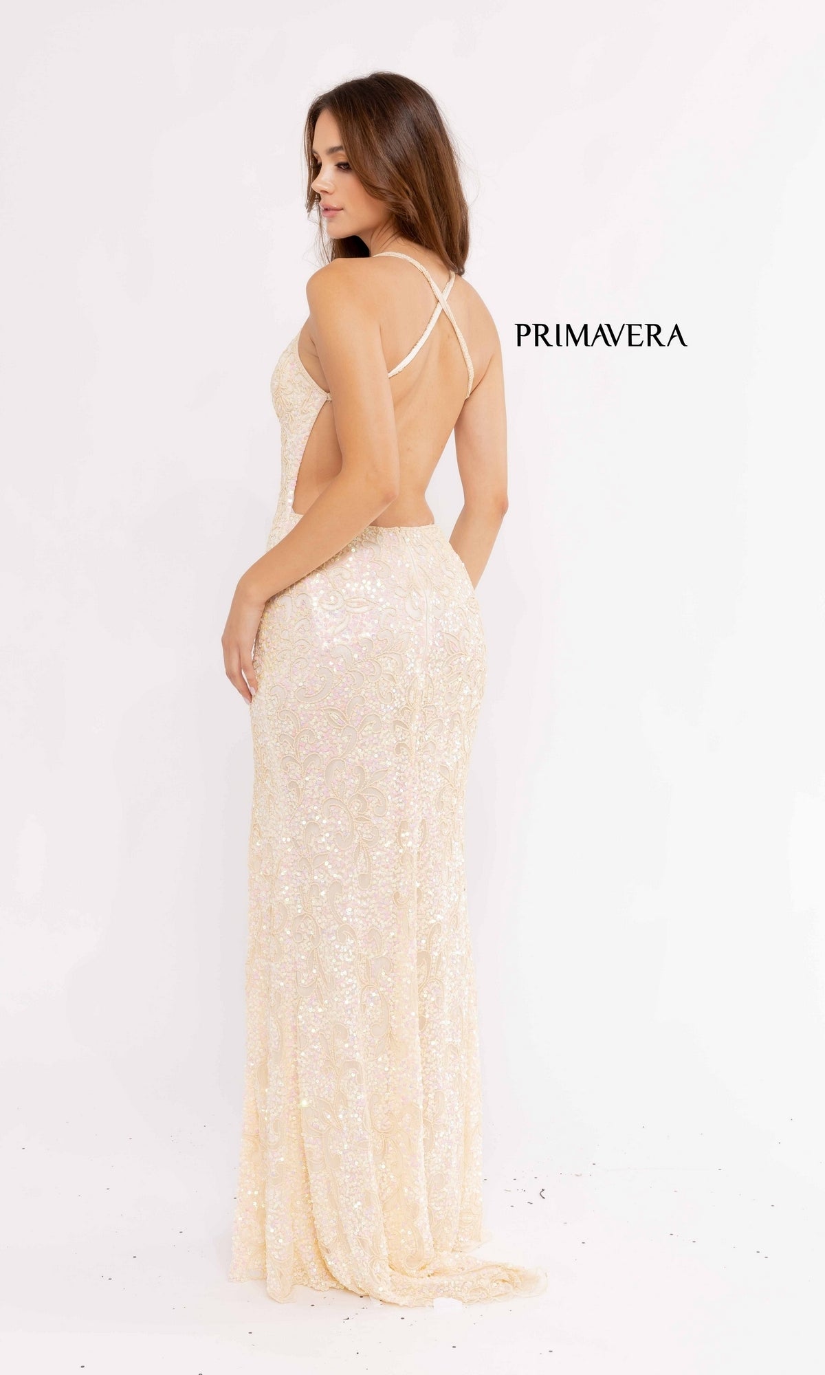 A woman in the Pastel Sequin-Pattern Long Prom Dress 3295, featuring a backless floor-length design in a light pastel shade, stands facing away against a plain white background. 
