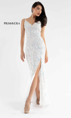 A woman wearing the Open-Back Primavera 3749 Long Sequin Prom Dress, a fitted white gown with thin straps and a thigh-high slit, posed against a plain white background.