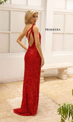 A woman wears the Strappy-Back Long Sequin Primavera 3761 Prom Dress, standing on a stone patio by a white bench and looking over her shoulder. "PRIMAVERA" and style number Primavera 3761 are displayed on the wall.