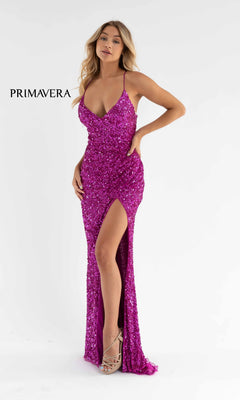 A woman models the Bright Wrap-Style Long Sequin Prom Dress 3791B, a sparkly fuchsia gown with a thigh-high slit and spaghetti straps, against a white background. "PRIMAVERA" is displayed on the left.