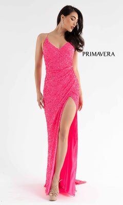A woman poses against a white background in the Bright Wrap-Style Long Sequin Prom Dress 3791B—a vivid pink, sparkly gown with thin straps and a high skirt slit—shining beside the word "PRIMAVERA.