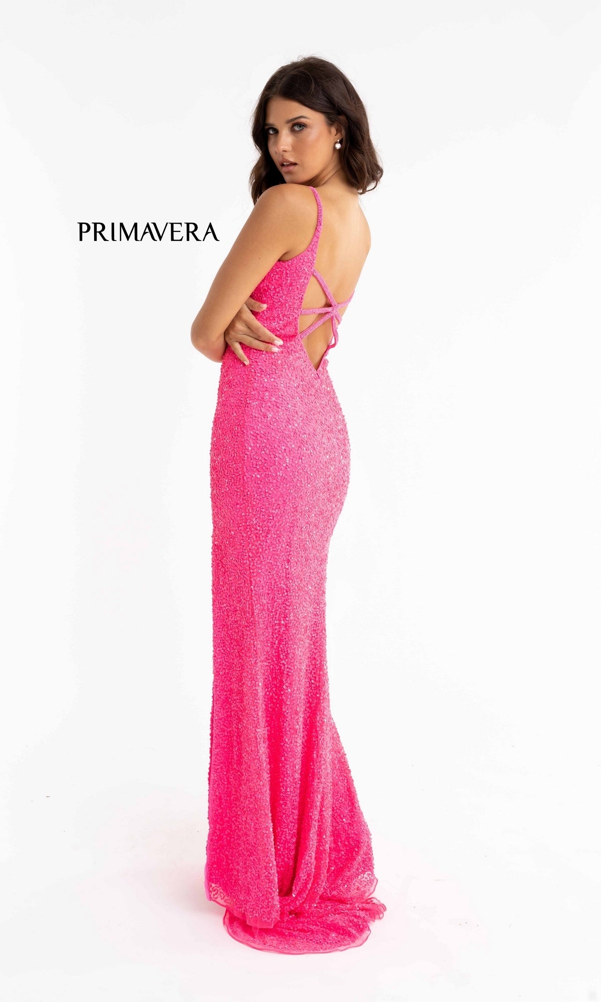 A woman poses in the Bright Sequin-Print Long Prom Dress 3792B, a fitted floor-length bright pink sequin gown with thin straps and an open back, against a plain white background. 