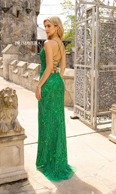 A woman in the Strappy-Back Long Sequin Prom Dress 3958 stands outdoors by a stone lion sculpture and an ornate metal gate.