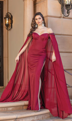 A woman stands elegantly on outdoor steps wearing an Off-Shoulder Prom Dress with Floor-Length Cape Sleeves, featuring a fitted burgundy silhouette and a thigh-high slit.