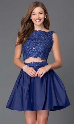 Woman in a Two-Piece Lace-Bodice Short Party Dress, featuring a sleeveless crop top and matching flared skirt, stands smiling against a plain grey background.
