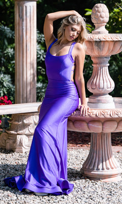 A woman in the Statement-Back Long Prom Dress by Atria, featuring a fitted, sleeveless purple design, sits on the edge of a stone fountain in an outdoor garden setting.