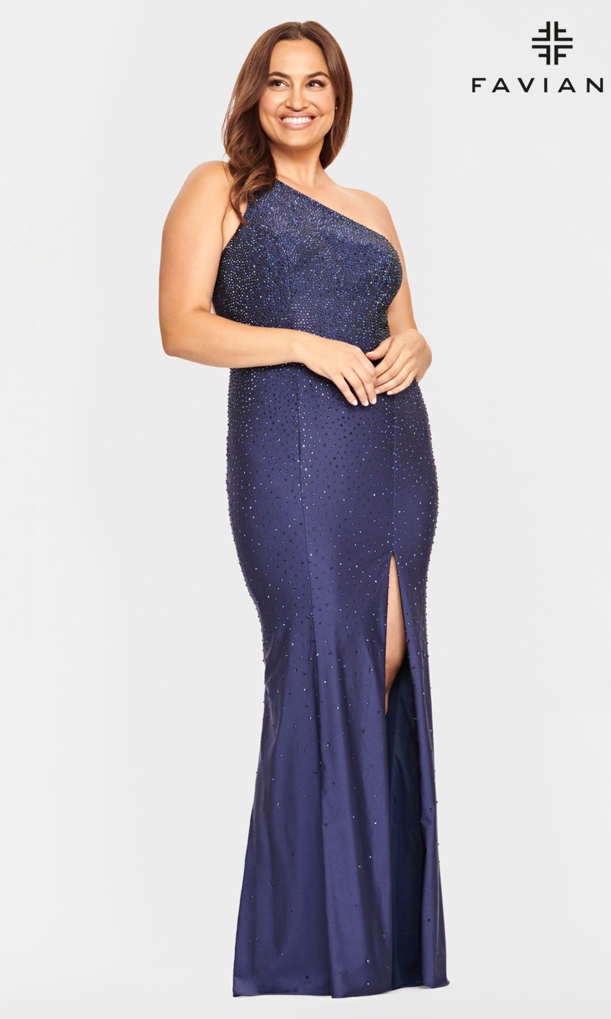 A woman smiles in the Faviana One-Shoulder Plus-Size Prom Dress 9532, a dark blue gown with bead detailing and a front slit. The 