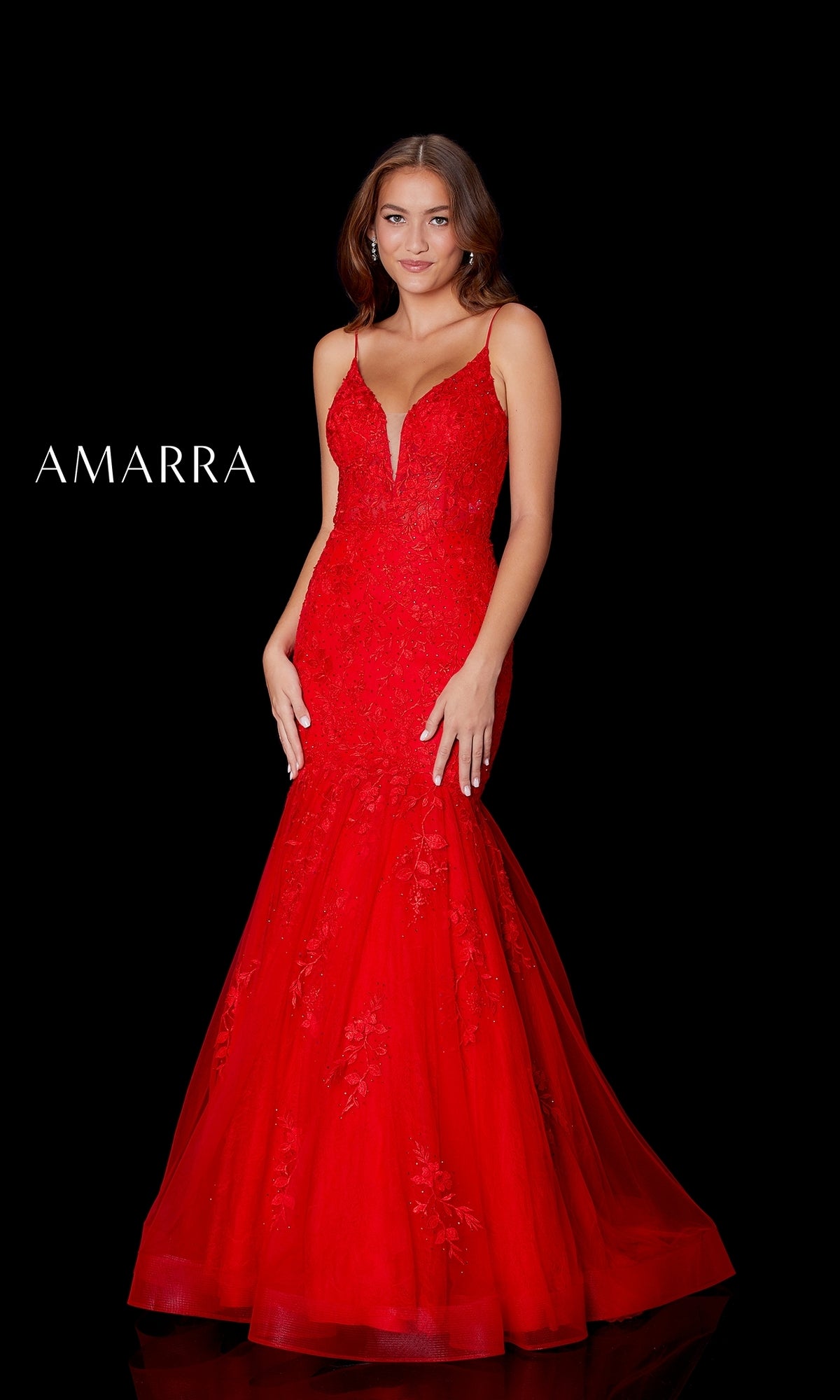 A woman models the Amarra 87226 Long Lace Mermaid Prom Dress—fitted red lace with thin straps—against a black background. 
