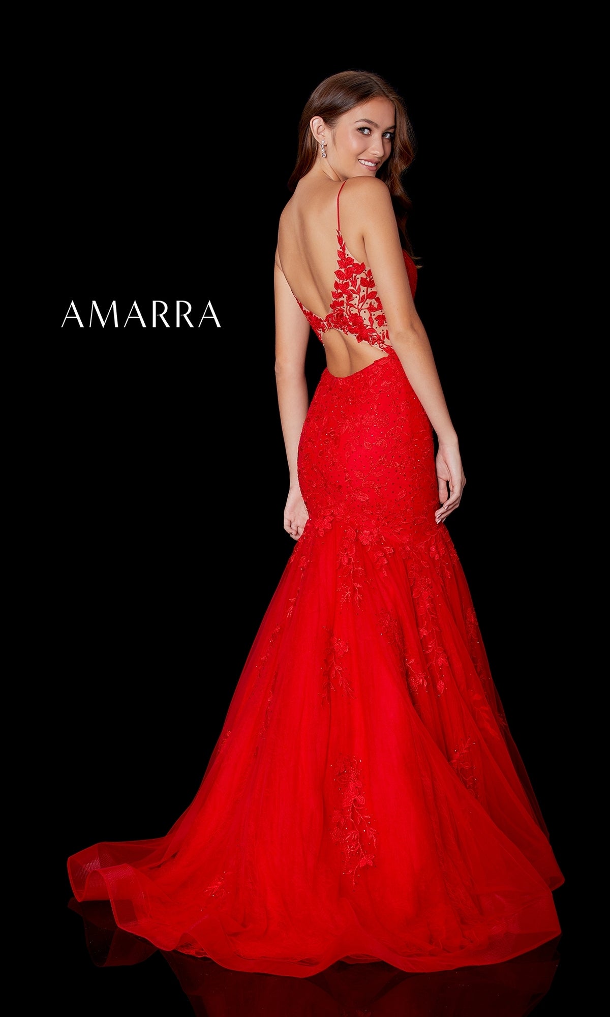 A woman models the Amarra 87226 Long Lace Mermaid Prom Dress—an elegant red, floor-length gown with thin straps and a low back—posing gracefully before a black background featuring 
