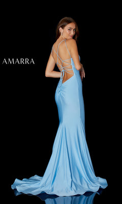 A woman poses against a black background in the Amarra 87243 Open-Back Simple Long Formal Gown, a light blue, floor-length dress featuring a lace-up open back. The word "AMARRA" appears on the left side.
