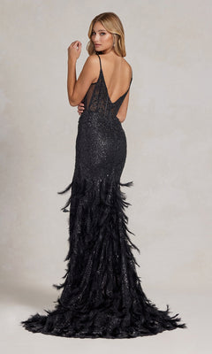 A woman wearing the Open-Back Shimmer Prom Dress with a feather skirt, sequin details, and a floor-length black design stands against a light neutral background.