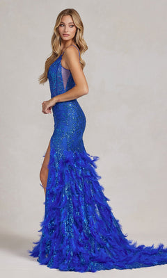 A woman with long blonde hair wears the Open-Back Shimmer Prom Dress with Feather Skirt, featuring sequins, a high slit, sheer corset, and flowing train, as she stands against a plain background.