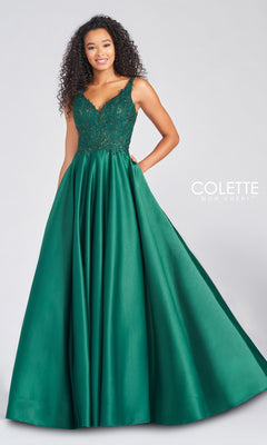 Woman wearing the V-Neck Satin Prom Dress by Colette by Daphne, featuring an embroidered bodice and full satin skirt in emerald green, stands against a plain background.