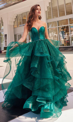 A woman stands outdoors wearing the Colette Glitter-Tulle Layered Long Prom Ball Gown—an emerald green, strapless ball gown with a fitted bodice and ruffled tulle skirt.