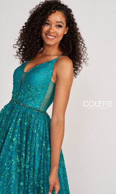 A woman smiles against a plain background, wearing the Backless Tulle Prom Ball Gown CL2016 with glitter print. The sleeveless teal dress features sequin embellishments, sheer side panels, and a full tulle skirt.