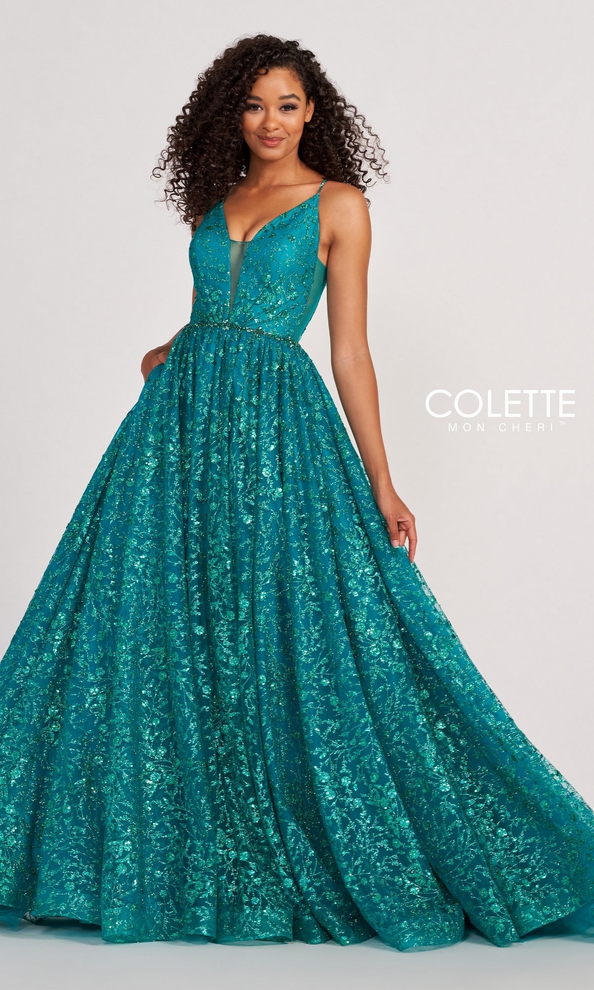 Woman wearing the Backless Tulle Prom Ball Gown CL2016 with glitter print, a deep teal, floor-length, sleeveless dress with sparkling details and a full skirt, posing in front of a plain background.