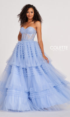 A woman wears the Colette CL2017 Strapless Ruffled Prom Ball Gown in light blue, featuring a sheer, beaded corset bodice and ruffled tulle skirt, standing against a plain background with the "Colette Mon Cheri" logo on the right.