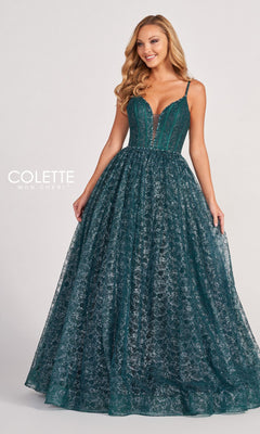 A woman poses against a plain background in the Colette CL2018 Deep V-Neck Glitter-Lace Ball Gown, a sleeveless deep green evening dress with a fitted bodice and a full, sparkling skirt.