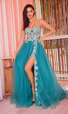 Woman wearing the Colette CL2020 Glitter-Lace Long A-Line Prom Dress, featuring white floral embroidery and a thigh-high slit, standing indoors beside pink curtains and wooden panels.