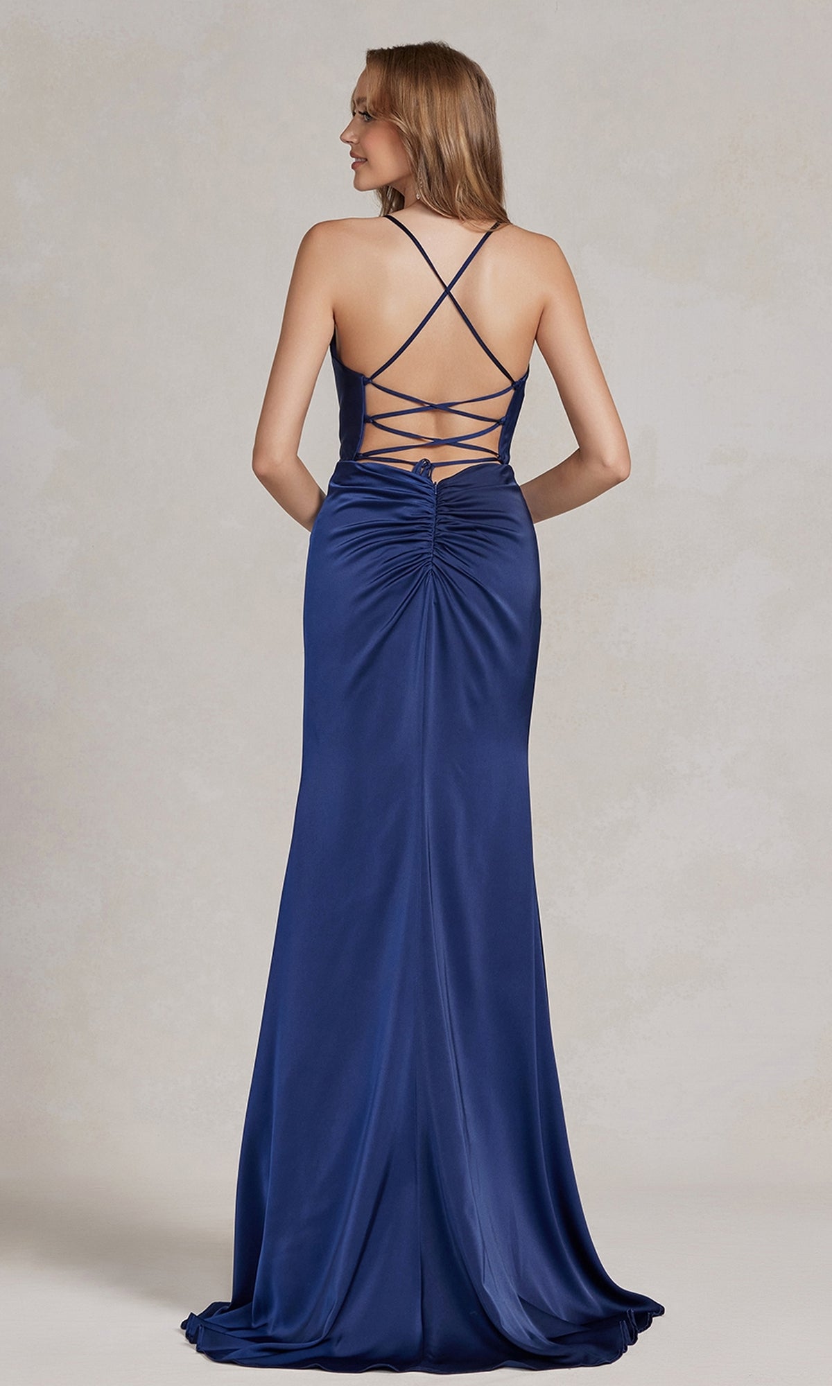 Woman in a deep blue Cowl-Neck Classic Prom Dress with crisscross back straps and side slit, shown from behind against a neutral background—an elegant choice for formal events.