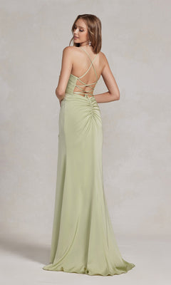 A woman stands facing away in the Cowl-Neck Classic Prom Dress with Side Slit—a light green, floor-length satin gown featuring ruched details and criss-cross straps—an elegant pick for any formal event.