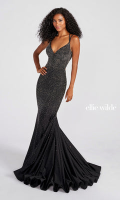 A woman models the Strappy-Back Long Beaded Ellie Wilde Formal Gown, a fitted black floor-length dress with sparkling embellishments and a flared mermaid hem, against a plain light background. "ellie wilde" is displayed on the right.