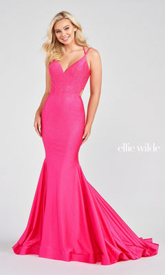 A woman wears the Strappy-Back Long Beaded Ellie Wilde Formal Gown, a fitted bright pink dress with thin straps, an open back, and flared train, standing against a plain light background.