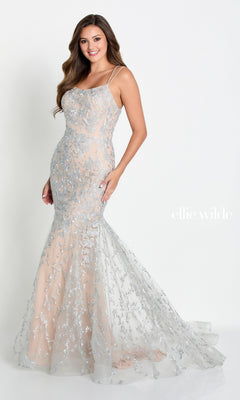 A woman wears the Long Lace Mermaid Prom Dress with Strappy Back, featuring silver floral-embroidered lace and thin straps. She stands against a plain white background, showing off the elegant open-back design.